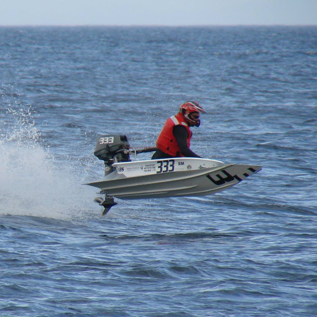 Shawn Lamoureux, co-founder of Island Electric Co., flying through the ocean waves during the Nanaimo Bathtub Race wearing a red helmet and life jacket